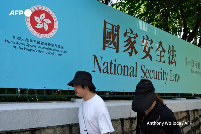 File photo: People walk past a banner for the National Security Law in Hong Kong on July 15, 2020 after Beijing imposed a controversial new security law. (Anthony Wallace / AFP)