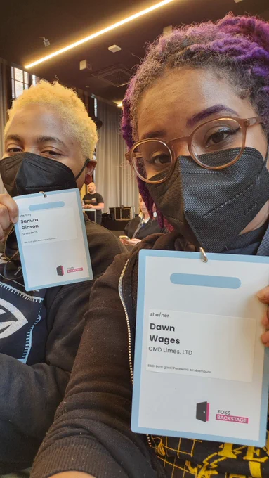 Wife and I holding up our name tags with both of our respective businesses.