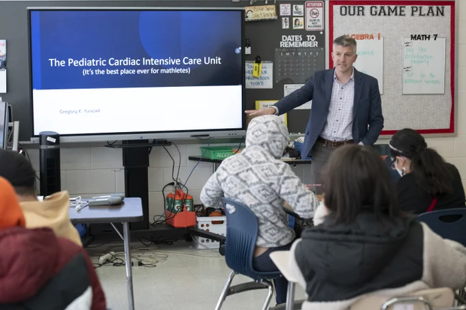 Doctor speaking to students during Career Day in a classroom.