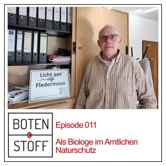 Thorsten Florin-Bisschopinck steht vor einem Regal, neben ihm ein Schild mit der Aufschrift: Licht aus für die Fledermaus.