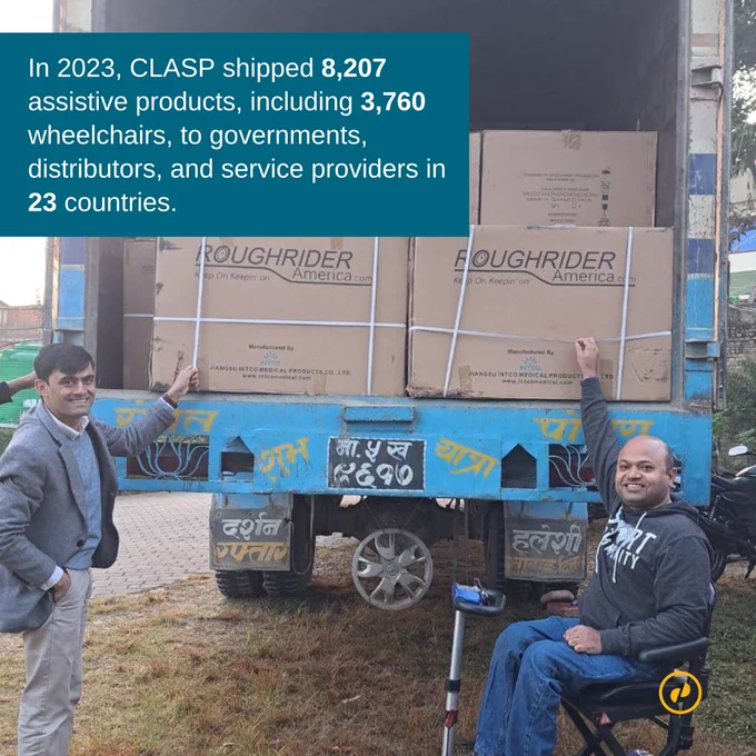 CLASP delivery to SIRC in Nepal. Pictured are two men in front of a shipping truck with the back open. The truck is piled high with boxes of wheelchairs. The man on the right in the photo is in a wheelchair. 