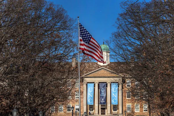 The American flag flies outside of South Building on the UNC-Chapel Hill campus