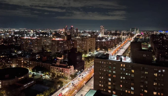 This image of Delancey Street and Williamsburg Bridge in Manhattan, New York City, at night, visually depicts community severance, highlighting the impact of major roadways on neighborhood connectivity.