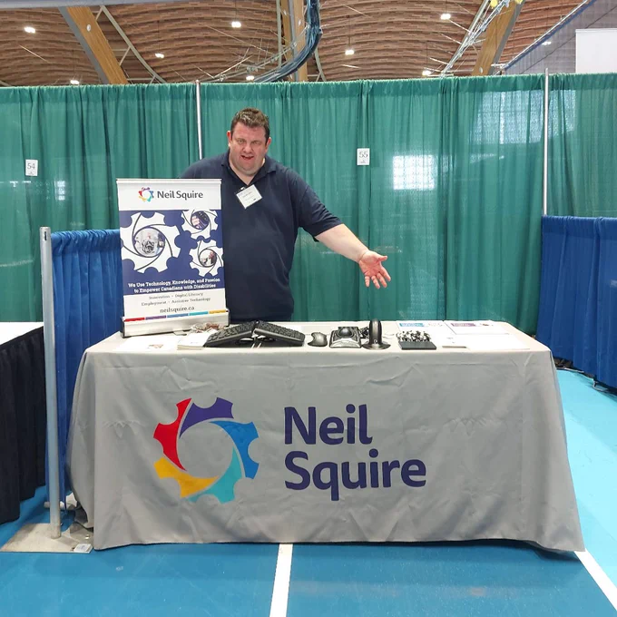 Gordon at the Neil Squire booth with an assistive technology display.