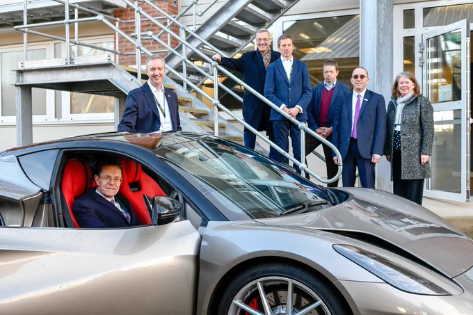 Andy Street sits in a sports car, whilst the Innovation Team stand outside, smiling for the camera. 