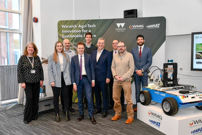 Andy Street and VC Prof Stuart Croft stand with Agri-Tech employees, smiling for the photo.