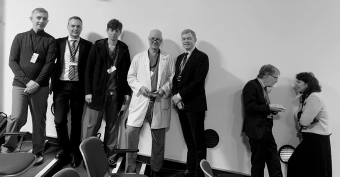 A group of wonder staff waiting for the event to begin. Standing on the sloping stairs against a wall