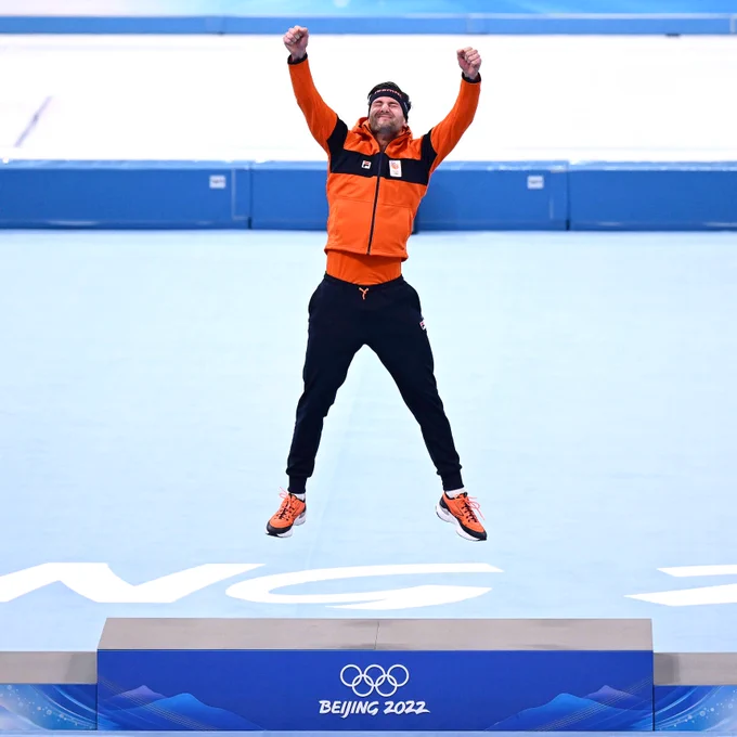 Thomas Krol springt in de lucht op het gouden olympische podium