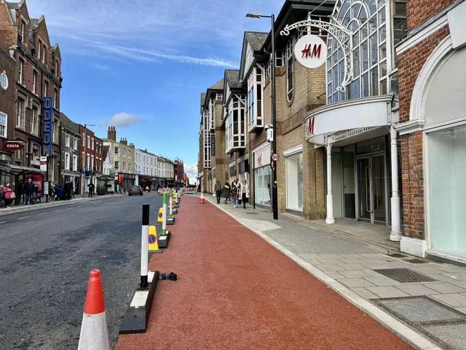 Red cycle lane between pavement and traffic lanes