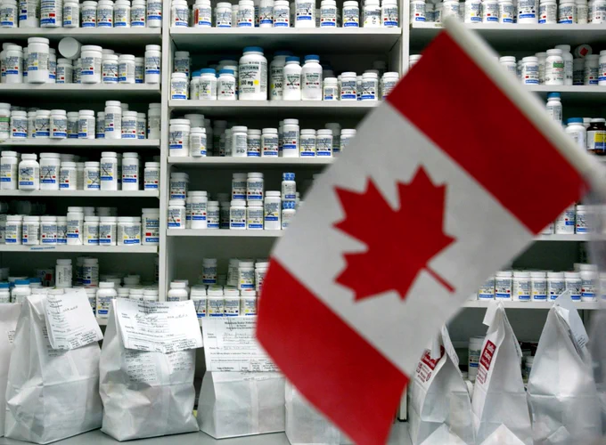A miniature Canadian flag sits in front a wall of prescription drugs. Copyright: JEFF HAYNES/AFP/Getty Images