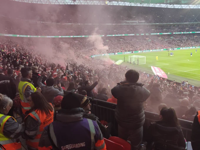 Liverpool end. Thousands of supporters. Red smoke billowing. An intense atmosphere!
