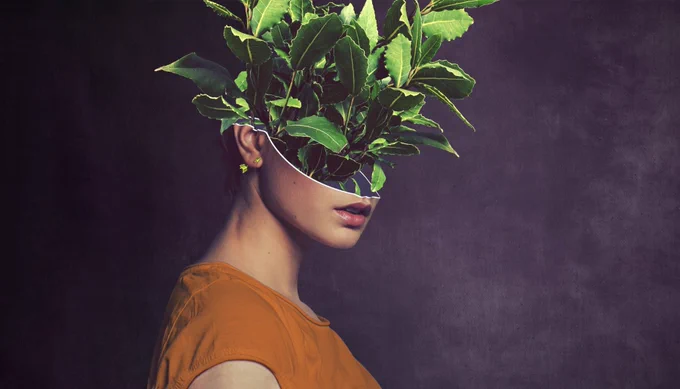 A woman wearing a yellow tshirt with a leafy plant photoshopped replacing the top half of her head
