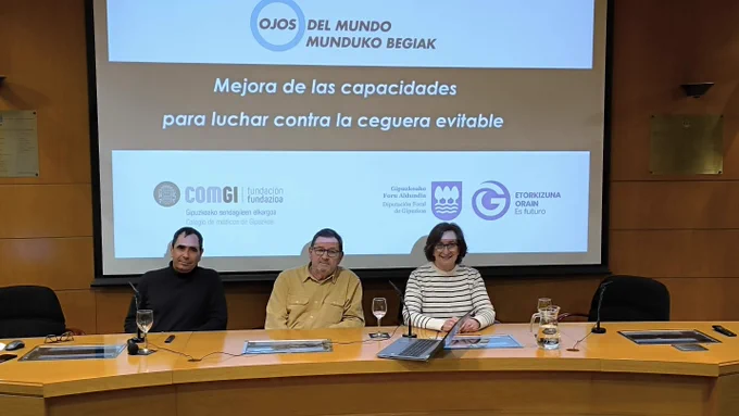 Fotografía de la sesión de trabajo en la sala de actos del colegio de médicos de Gipuzkoa, con los tres ponentes Alfonso Noboa, Andrés Müller-Thyssen y Miren Rodríguez, y en la pantalla el título de la presentación: "Mejora de las capacidades para luchar contra la ceguera evitable", con el logotipo de Ojos del mundo y los colaboradores: la Diputación de Gipuzkoa y la Fundación del Colegio de Médicos de Gipuzkoa.
