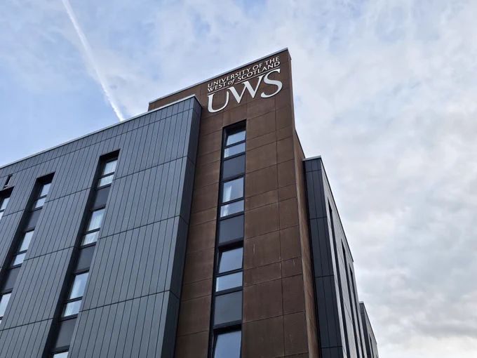 UWS building against a blue, part cloudy sky