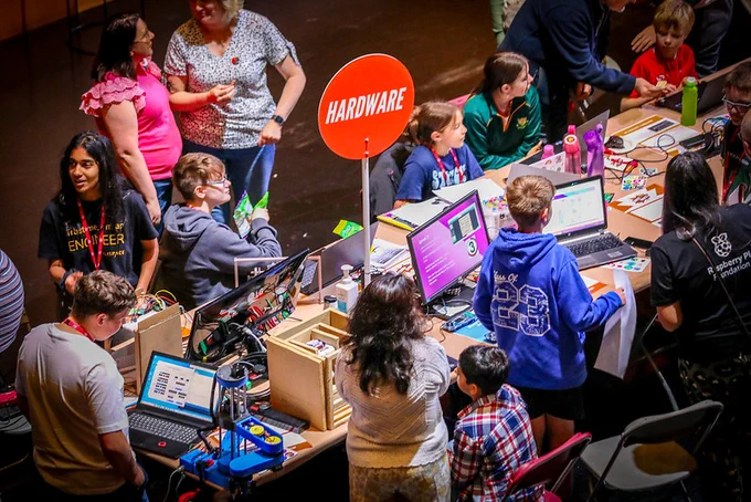 A group of young creators, mentors and parents all around a table of their digital makes at Coolest Projects Ireland 2023
