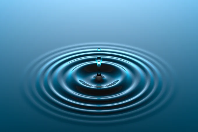 A water droplet falling into water surface. 