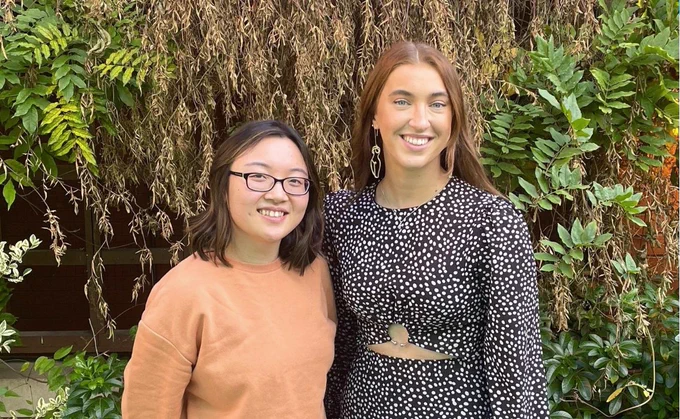 Two women founders at Eleria standing together and smiling in front of foliage
