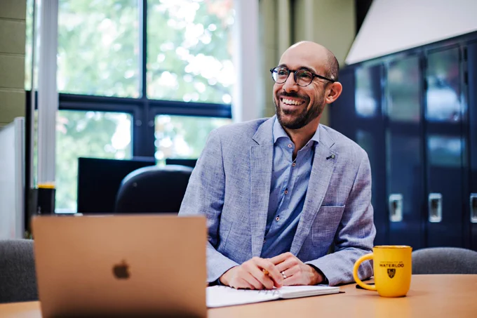 Dr. Chris Fletcher smiling inside of an office at the University of Waterloo
