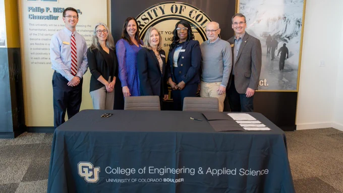 CU Boulder Provost Russell Moore, CU Engineering Dean Keith Molenaar, and president of Front Range Community College, Dr. Colleen Simpson along with several other dignitaries shown standing in front of table w CU Engineering logo'd tablecloth.