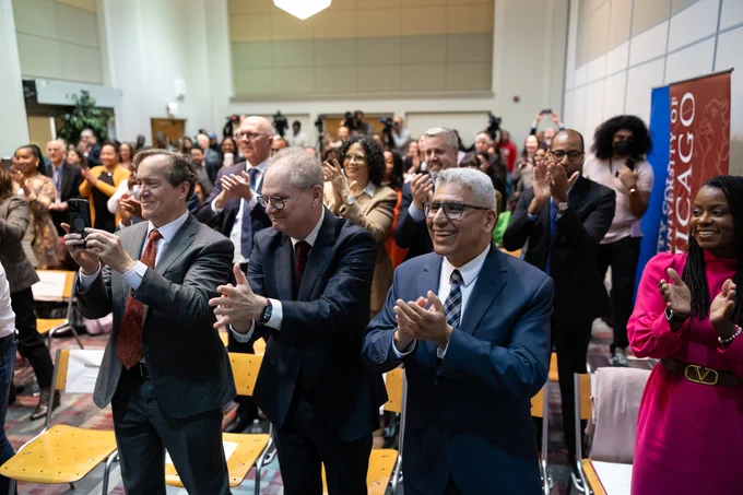 A large crowd of formally dressed people give a standing ovation.