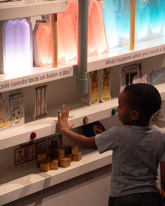 A picture of a young boy pressing buttons in Ada Twist's section of 'The Questioneers' exhibit.