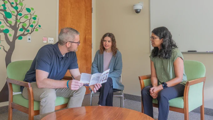 Dr. Dillon Browne talking to two patients inside the FamilyPsycle Lab at the University of Waterloo