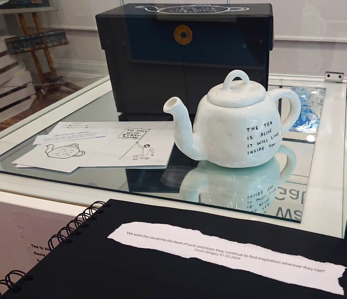 David Shrigley teapot on display at The Brampton Museum with visitor book including good luck message from the artists to the young curators.