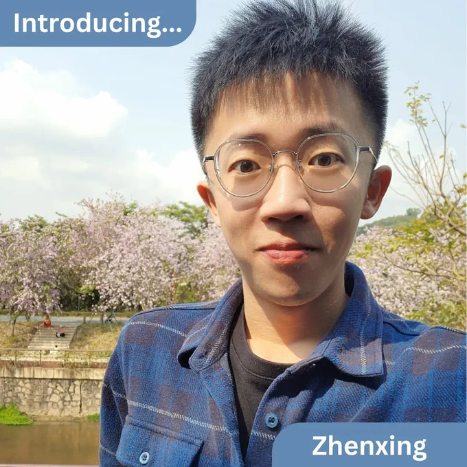 A photograph of zhenxing standing outdoors with cherry blossoms in the far background 