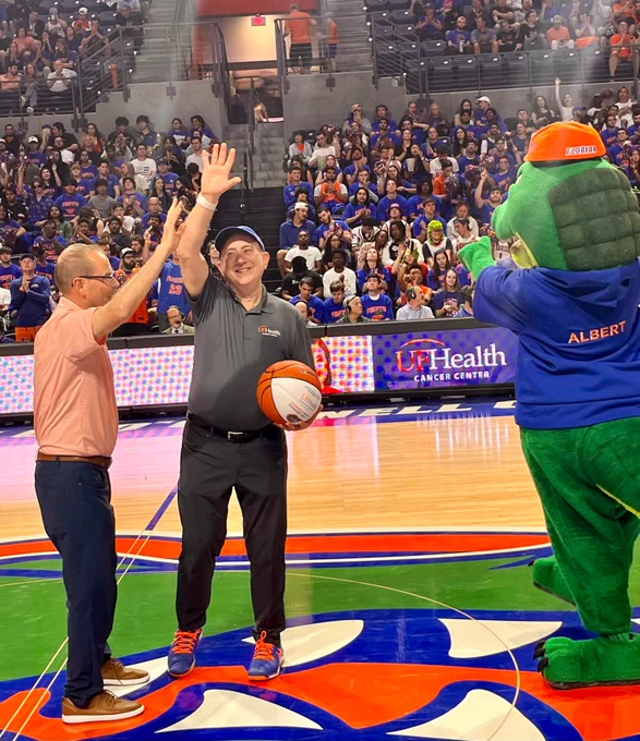 Dr. Licht gives a high-five while being recognized on court at the Gators men's basketball game.