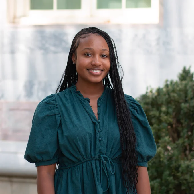 Portrain of Taylor Hailstock standing in front of a building on the Emory quad