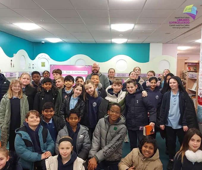Author PG Bell in a group photo with children at Port Talbot Library. 