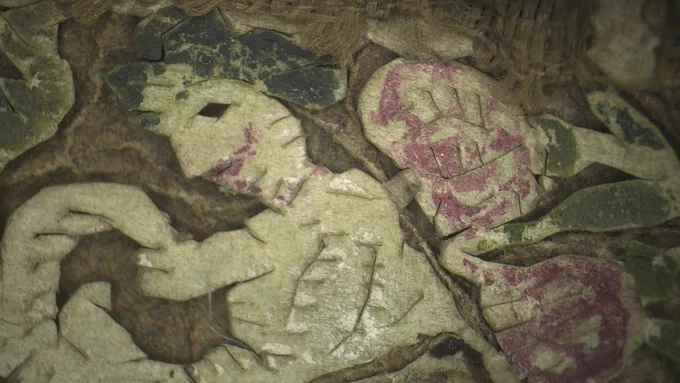 Enlarged/close up of white figure with pigments and stitching.