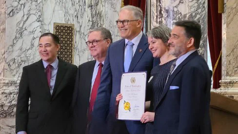 Governor Jay Inslee presenting the award to Dr. Bergman's children.