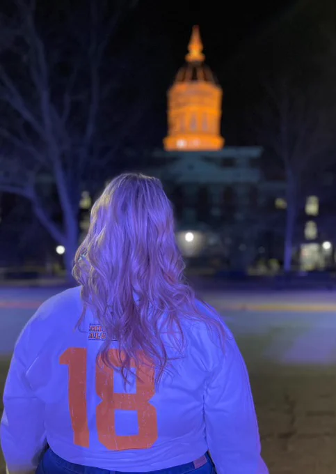 Alaina faces away from the camera so the big number "18" can be seen clearly on the back of her white shirt.