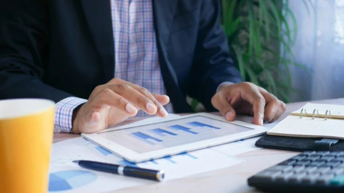 Person typing and designing bar graphs on a tablet