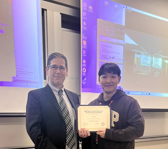 Ph.D. student Junepyo Oh receiving the 2023 Outstanding Ph.D. Graduate Student award by Department Head, Dr. Phillip Kaufman.