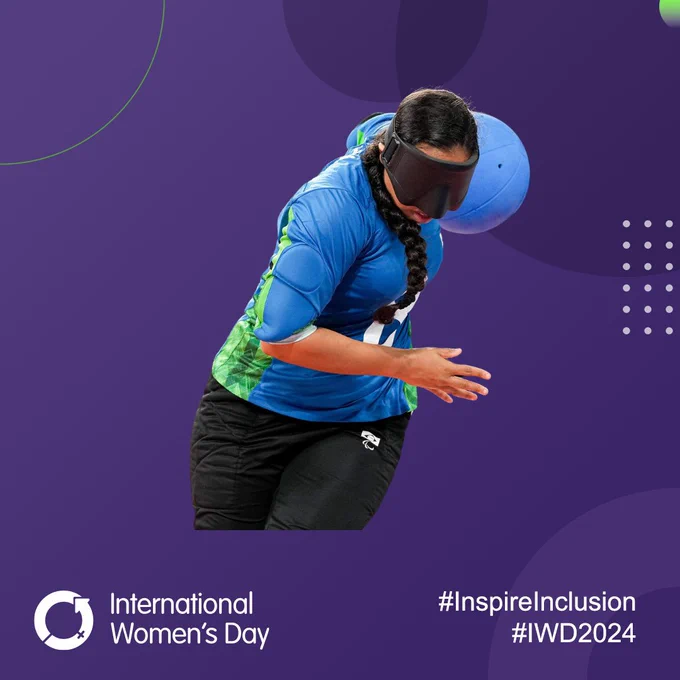 A female goalball player from Brazil holds the ball behind her as she twists during a shot