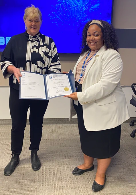 Mayor of Whitby, Elizabeth Roy, presenting a proclamation certificate for Neurodiversity Celebration Week to Natalie Dash, Accessibility Coordinator at the Region of Durham. 