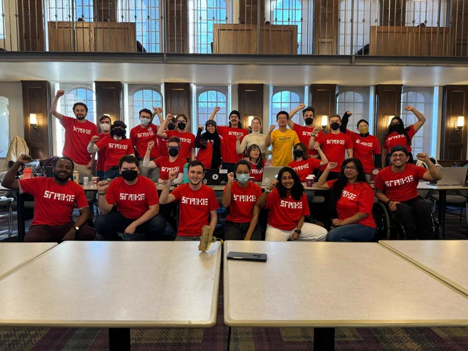 NUGW bargaining committee holds fists up with strike shirts on