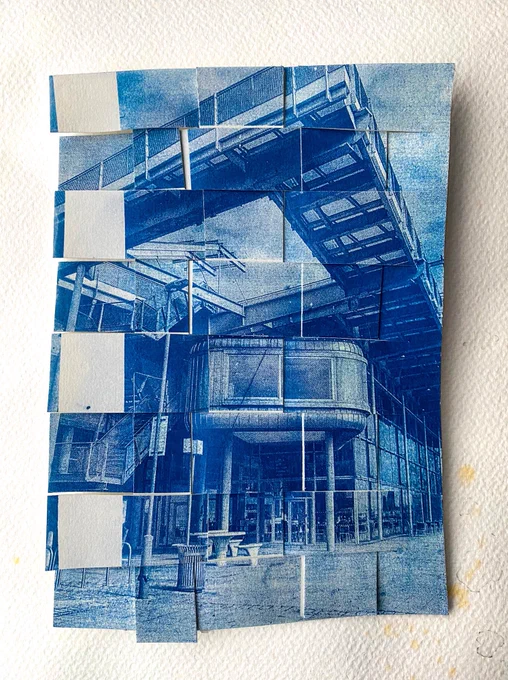 A woven paper blue photograph of an amazing industrial building. Alien like. Angular. Curvy. Proper mint building.