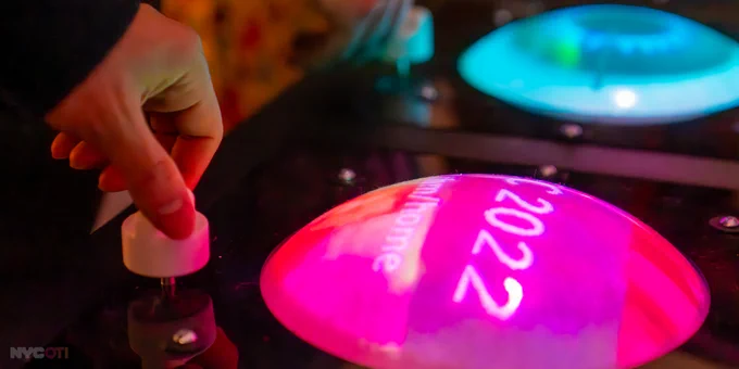 small circular lcd screen laying flat with an image, hand turning a white knob