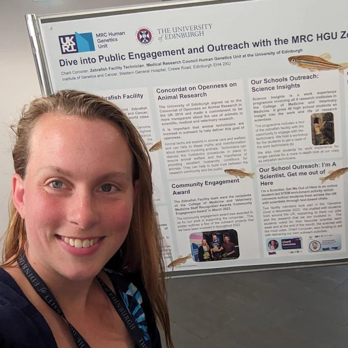 Image of Charli in front of her poster on public outreach.