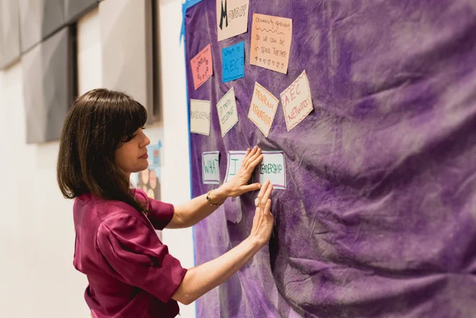 AEC Director planning, pinning notecard to wall