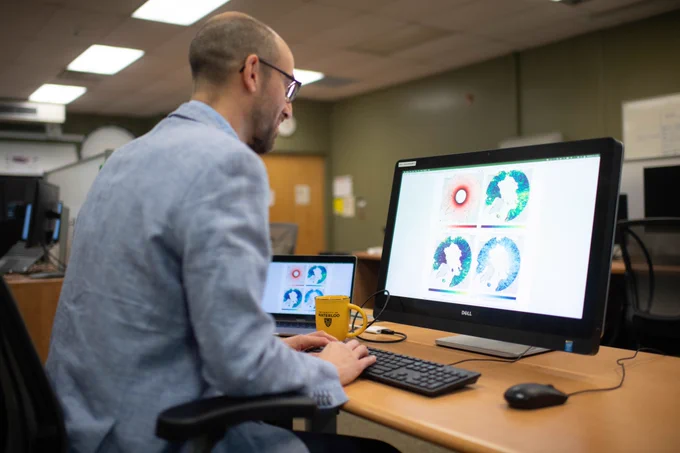 Dr. Chris Fletcher looking at weather patterns on a computer screen