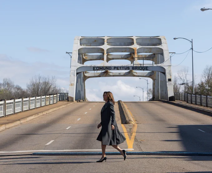 Vice President Harris walking in front of the Edmund Pettus Bridge. 
