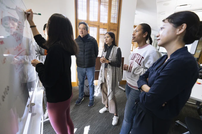 Four students and one project partner gather around a whiteboard in the Stanford Law School as part of a brainstorming exercise about fisheries and aquaculture. One student maps out ideas on the board. Photo credit: Andrew Brodhead.