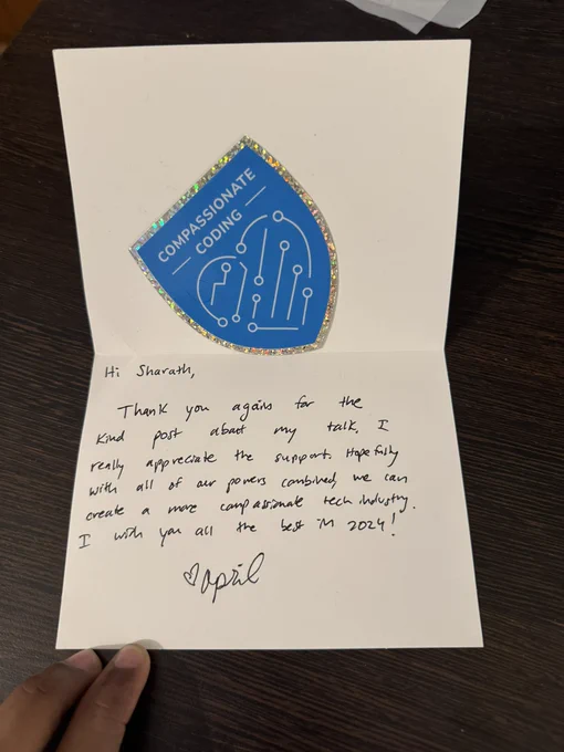 A letter from April thanking me for the post about her talk along with a Compassionate Coding Sticker. The letter reads - “Hi Sharath, thank you again for the kind post about my talk, I really appreciate the support. Hopefully with all of our powers combined, we can create a more compassionate tech industry. I wish you all the best in 2024! - April”