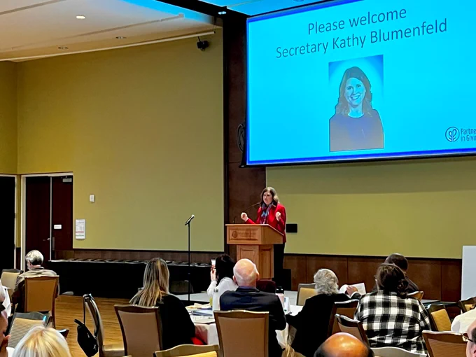 Partners in Giving volunteers listen to DOA Secretary Kathy Blumenfeld present remarks during the awards luncheon on March 5, 2023