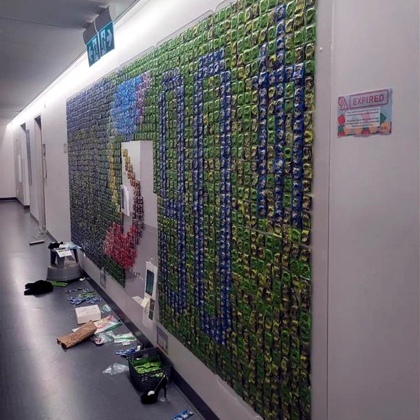 An image of the the condom mural in progress. It is mostly completed, but some of th white wall is showing through in some areas. 
