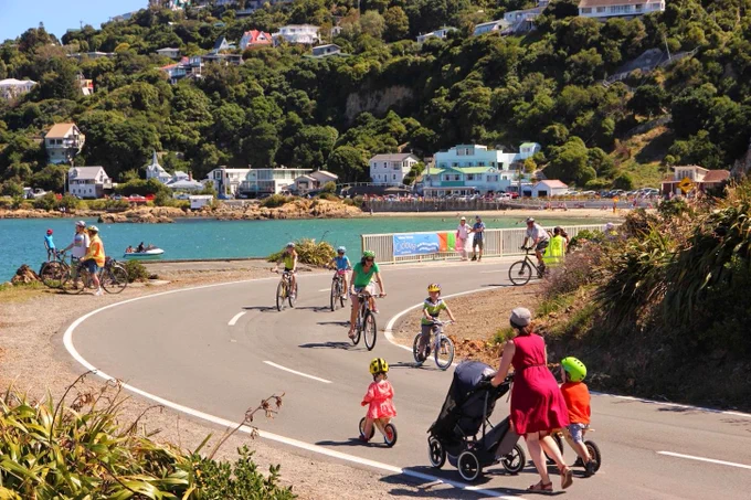 Families walking and biking along the Miramar Peninsula coastal road. 